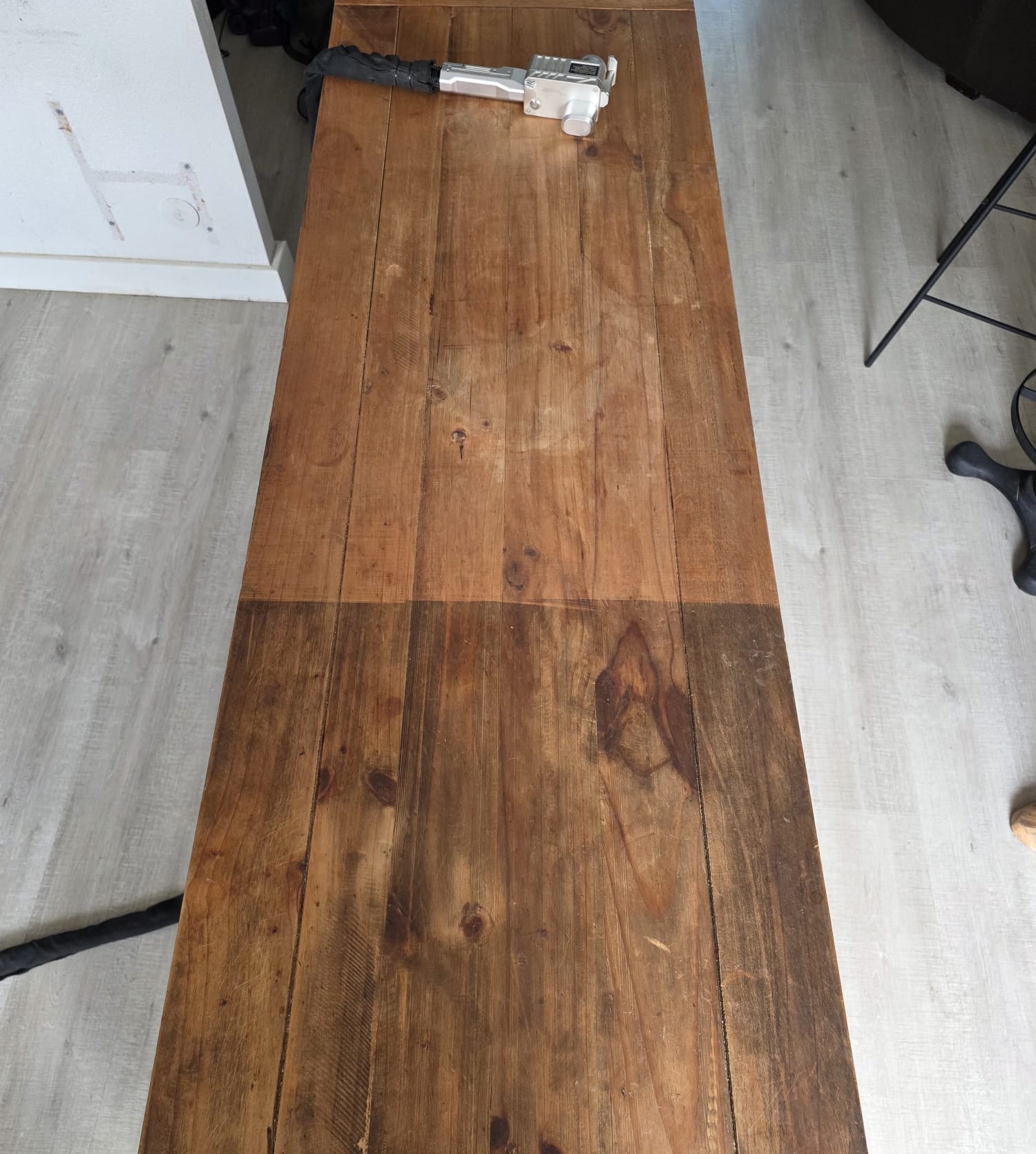 Décapage laser en cours sur une table en bois